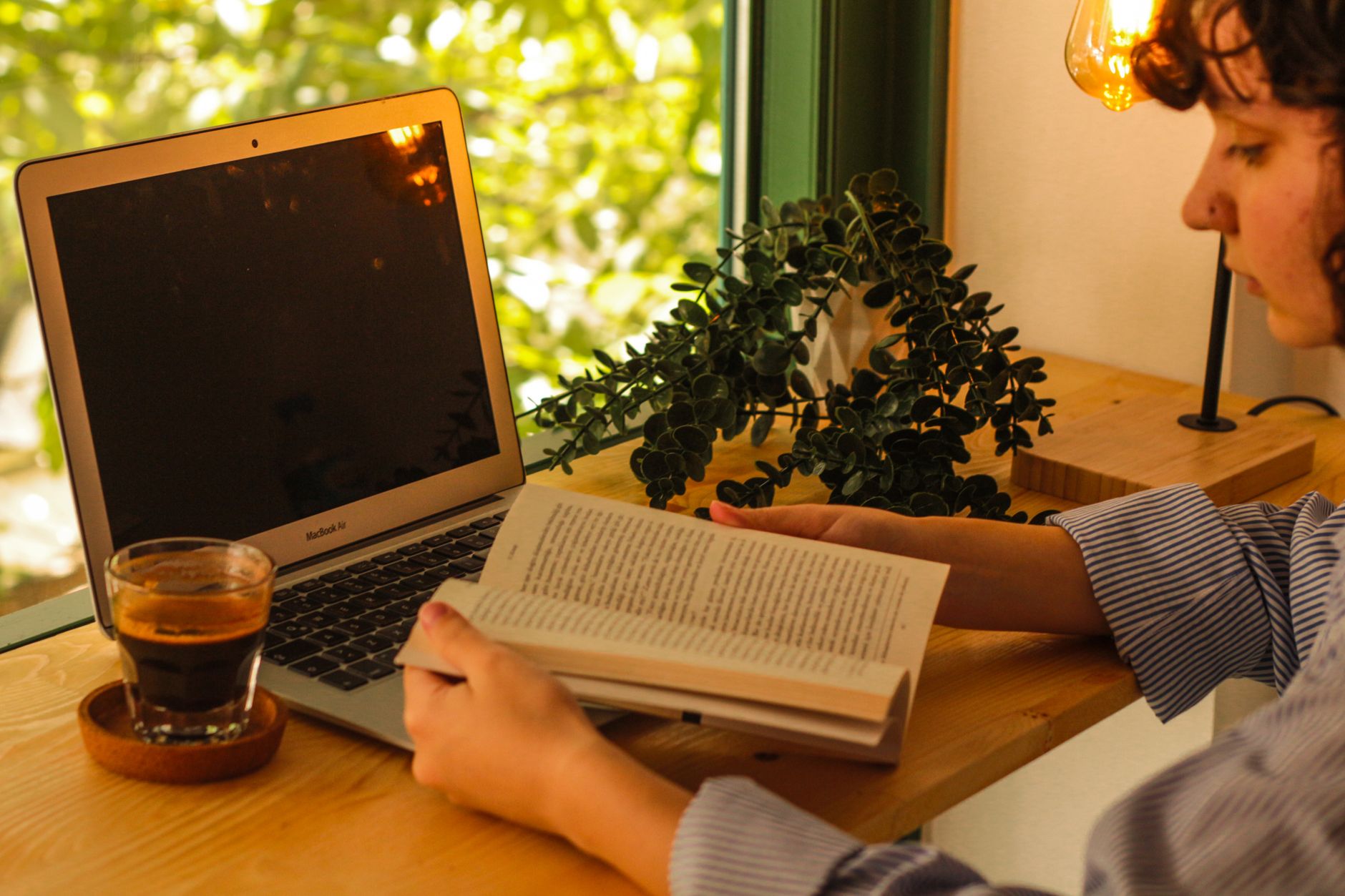 Een warme werkplek met een laptop, koffie en een boek