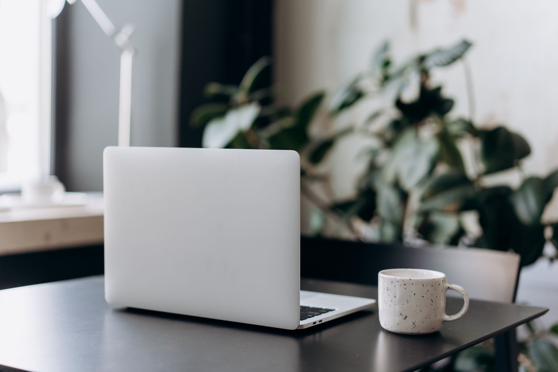 Een minimalistische werkplek met een gesloten laptop en een koffiekop